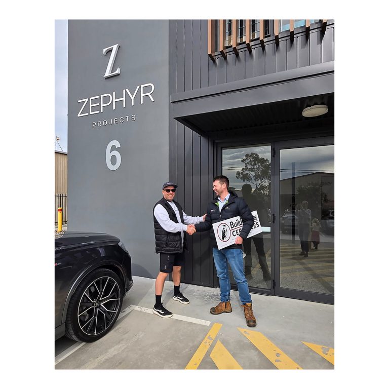 Daniel Deane from Zephyr Projects, left, and Kurt Moroney, right, from Buildingwise Certifiers shaking hands outside the newly certified commercial premises at Cardiff NSW. 1 of 4.
