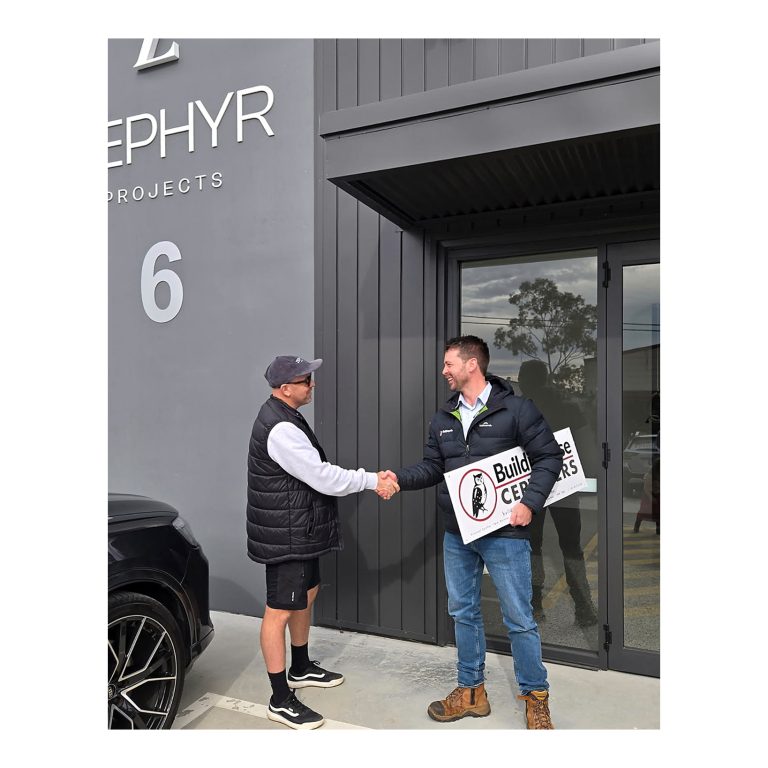 Daniel Deane from Zephyr Projects, left, and Kurt Moroney, right, from Buildingwise Certifiers shaking hands outside the newly certified commercial premises at Cardiff NSW. 2 of 4.
