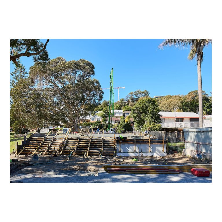 Wide perspective of extensive wooden formwork, retaining walls, and temporary support structures on a residential construction site in Merewether NSW.